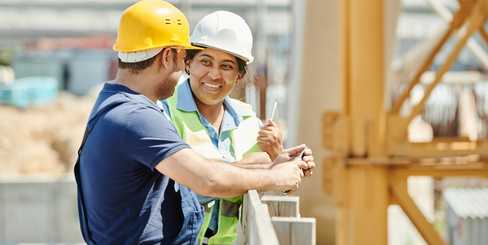 two people wearing hard hats chatting